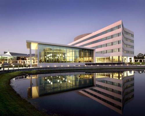 Exterior photo of Cafeteria and Office Building reflecting in retention pond